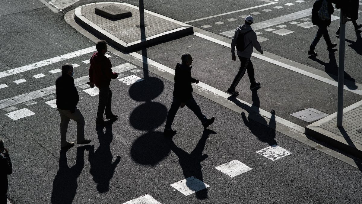 A group of people walking across a street.