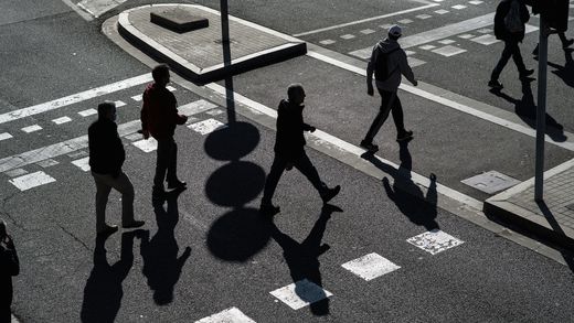 A group of people walking across a street.